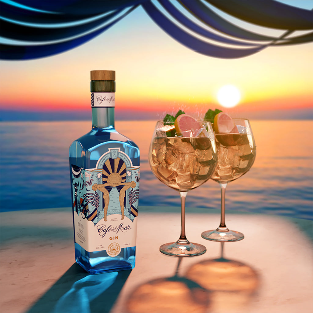 A bottle of Café del Mar Gin on a table at sunset