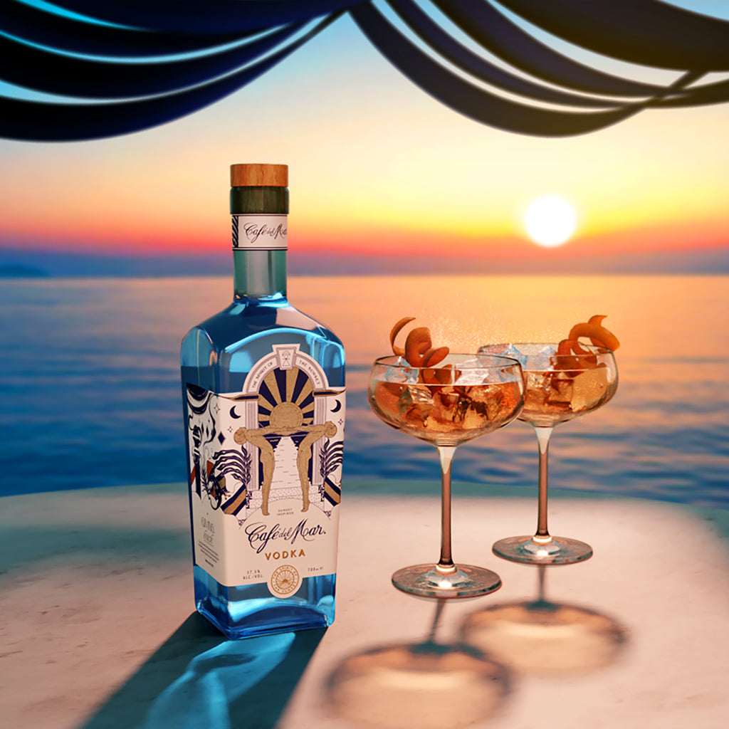A bottle of Café del Mar Vodka on a table at sunset